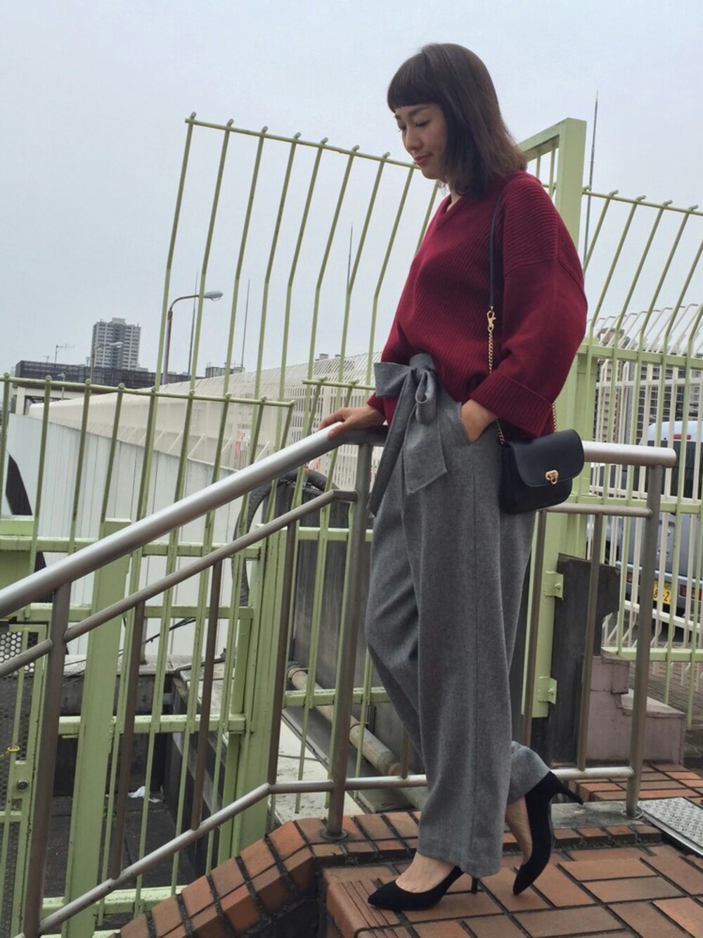 ブラック系のパンプス、ブラック系のショルダーバッグ、ブラック系のニット/セーターを着用したレディースの秋コーディネートの1枚目の写真