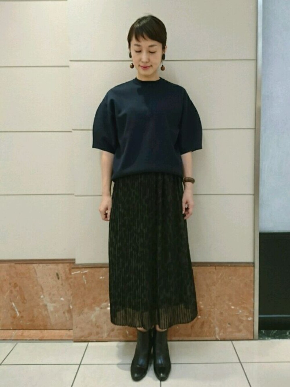 ブルー系のニット/セーター、グリーン系のスカート、ブラック系のブーツを着用したレディースの秋コーディネートの1枚目の写真