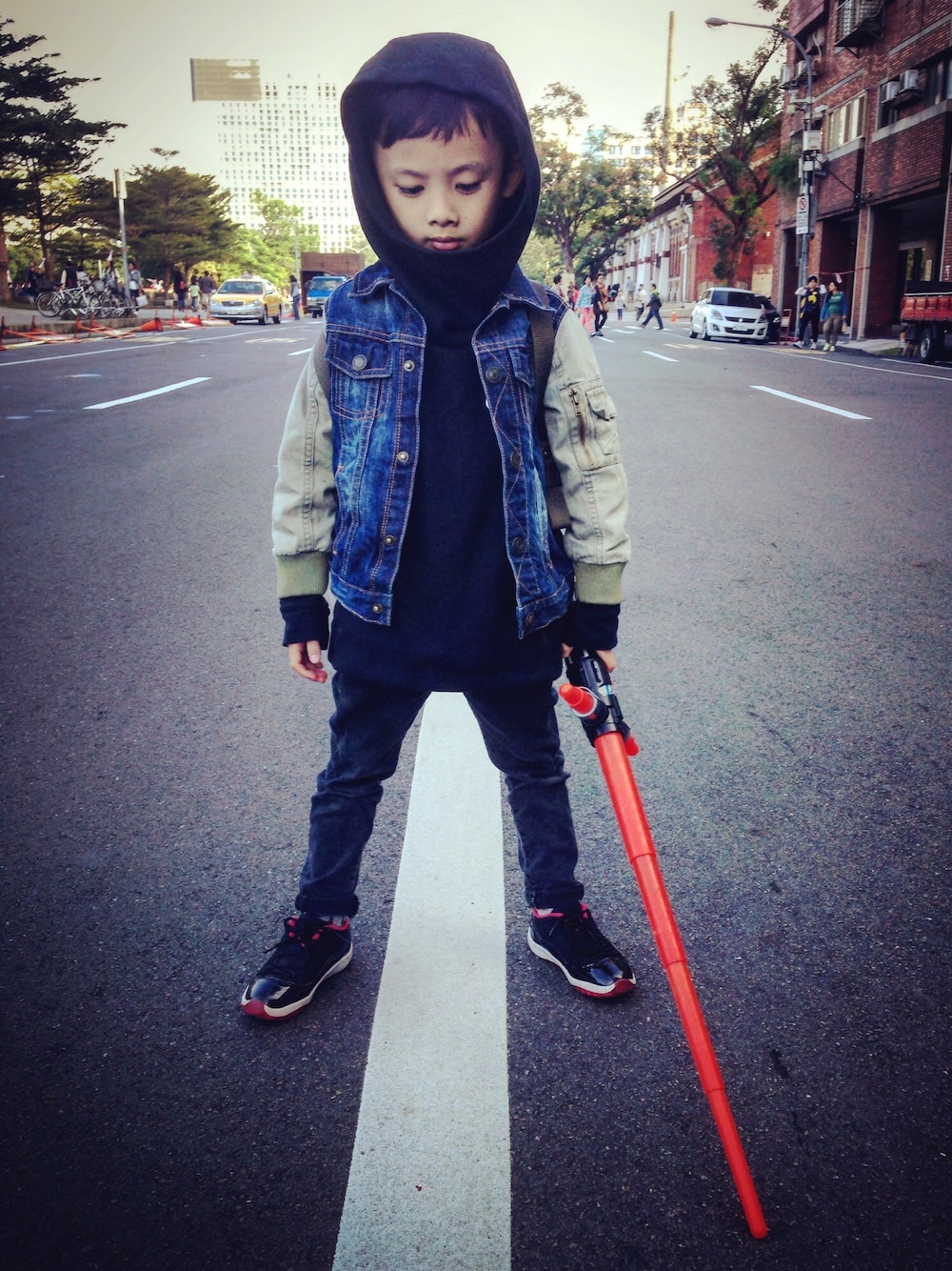 ブルー系のデニムジャケット、ブラック系のパーカー、ブラック系のデニムパンツを着用したキッズの秋コーディネートの1枚目の写真