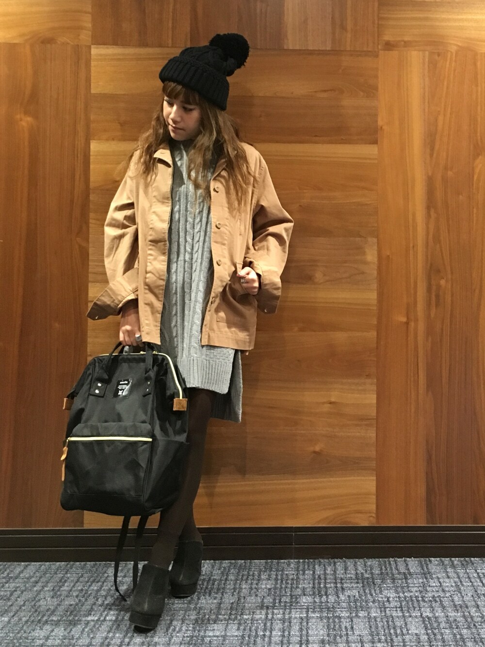 ベージュ系のミリタリージャケット、ブラック系のバックパック/リュック、グレー系のベストを着用したレディースの秋コーディネートの1枚目の写真