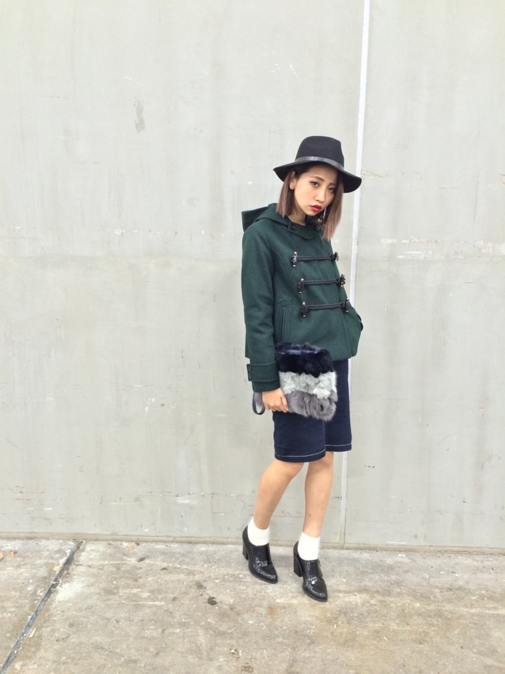 グリーン系のダッフルコートを着用したレディースの冬コーディネートの1枚目の写真