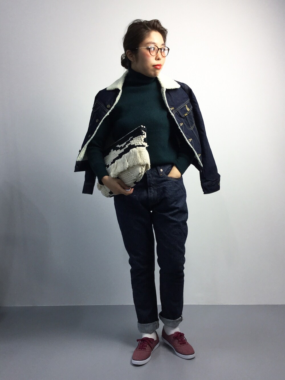 レッド系のスニーカー、ブルー系のデニムジャケット、ブルー系のデニムパンツを着用したレディースの秋コーディネートの1枚目の写真