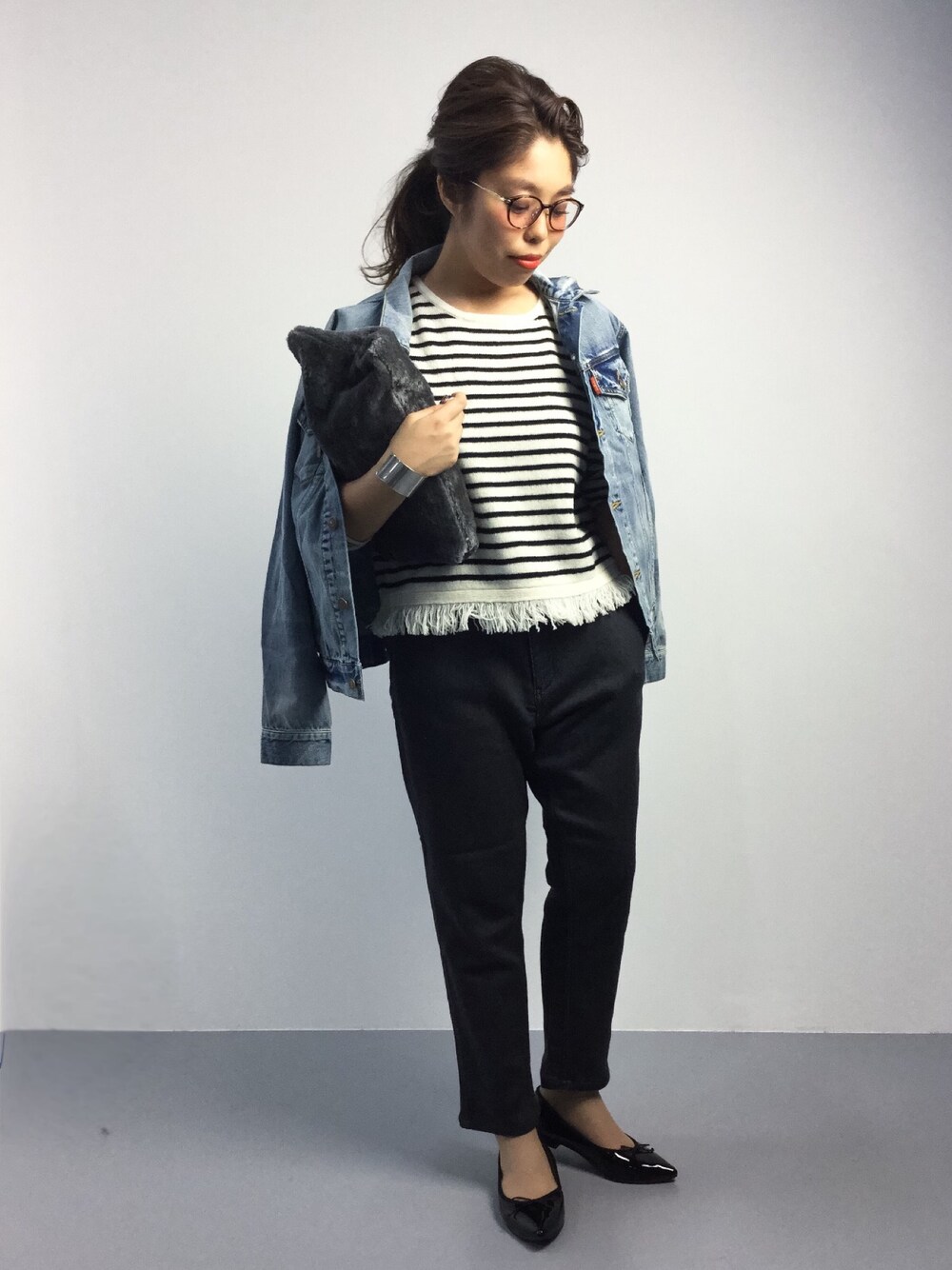 ブルー系のデニムジャケット、その他のニット/セーター、グレー系のクラッチバッグを着用したレディースの秋コーディネートの1枚目の写真