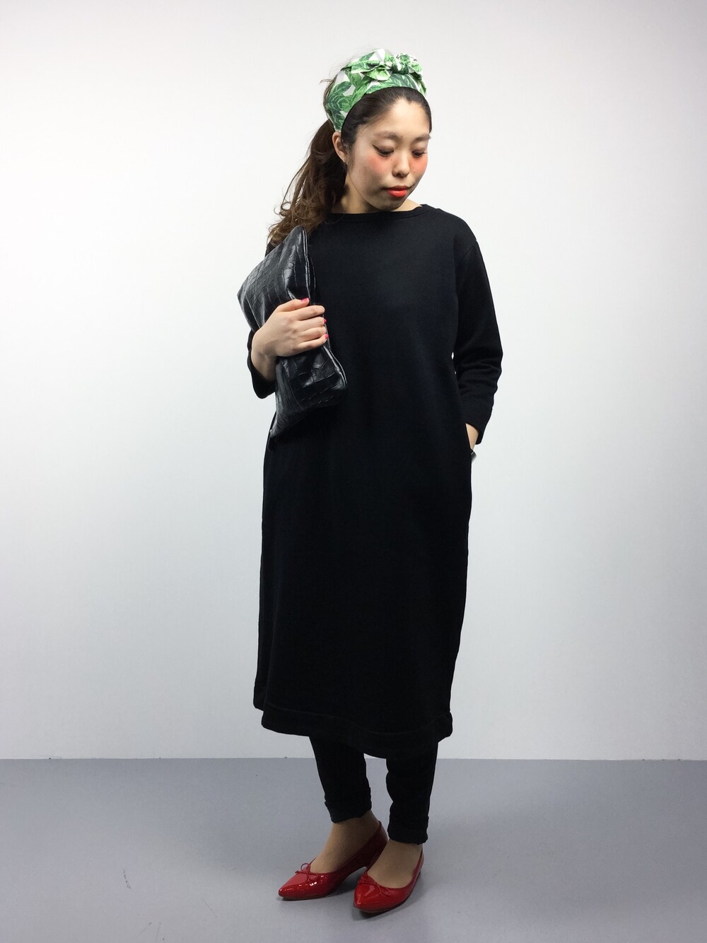 ブラック系のクラッチバッグ、ブラック系のワンピース、ブラック系のデニムパンツを着用したレディースの冬コーディネートの1枚目の写真