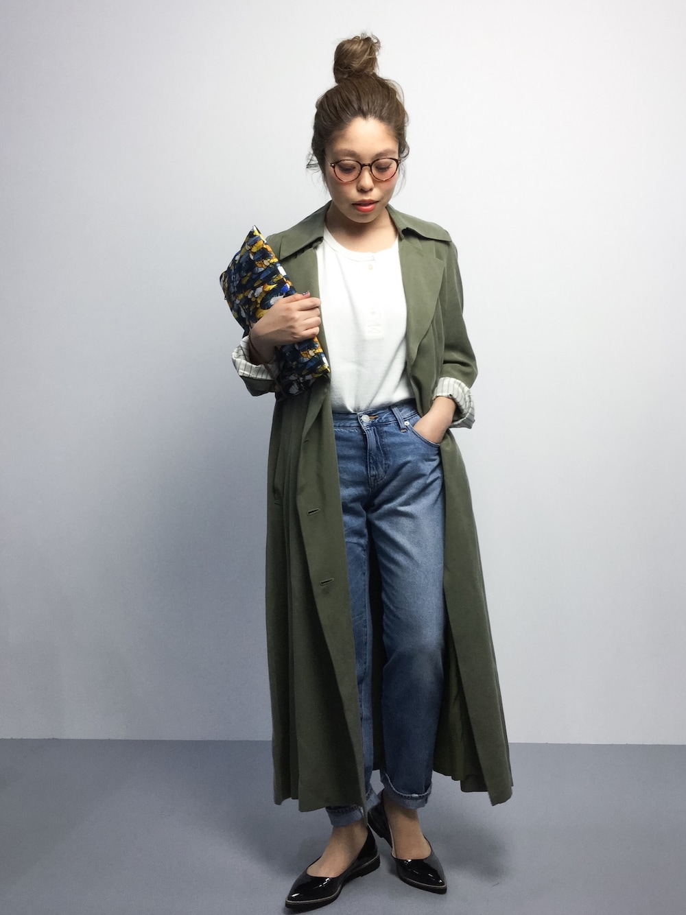 ホワイト系のTシャツ/カットソー、グリーン系のトレンチコート、ブルー系のクラッチバッグを着用したレディースの春コーディネートの1枚目の写真