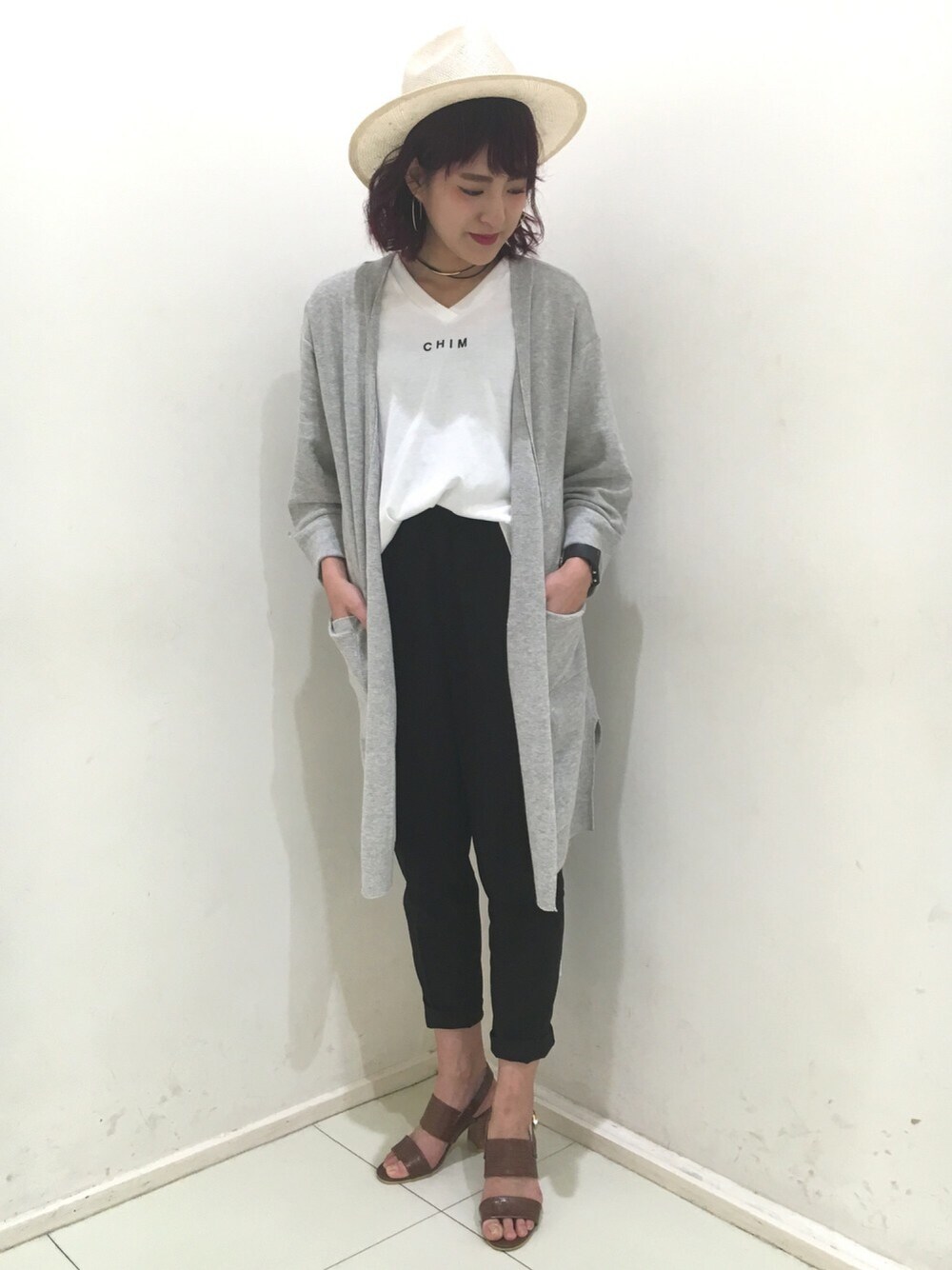 グレー系のカーディガン/ボレロ、ホワイト系のTシャツ/カットソー、ブラウン系のサンダルを着用したレディースの春コーディネートの1枚目の写真