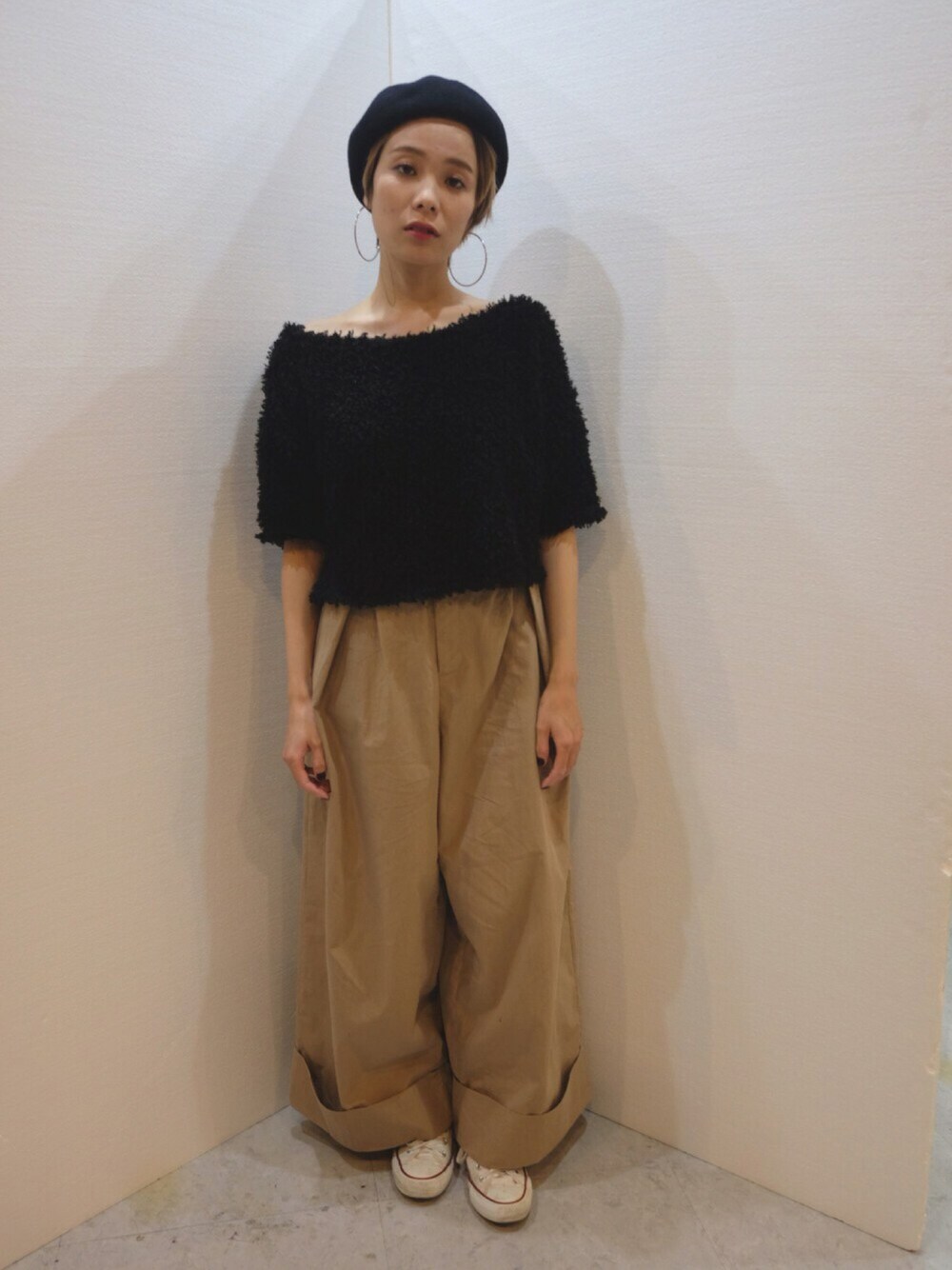 ベージュ系のパンツ、ホワイト系のスニーカー、ブラック系のハンチング/ベレー帽を着用したレディースの秋コーディネートの1枚目の写真