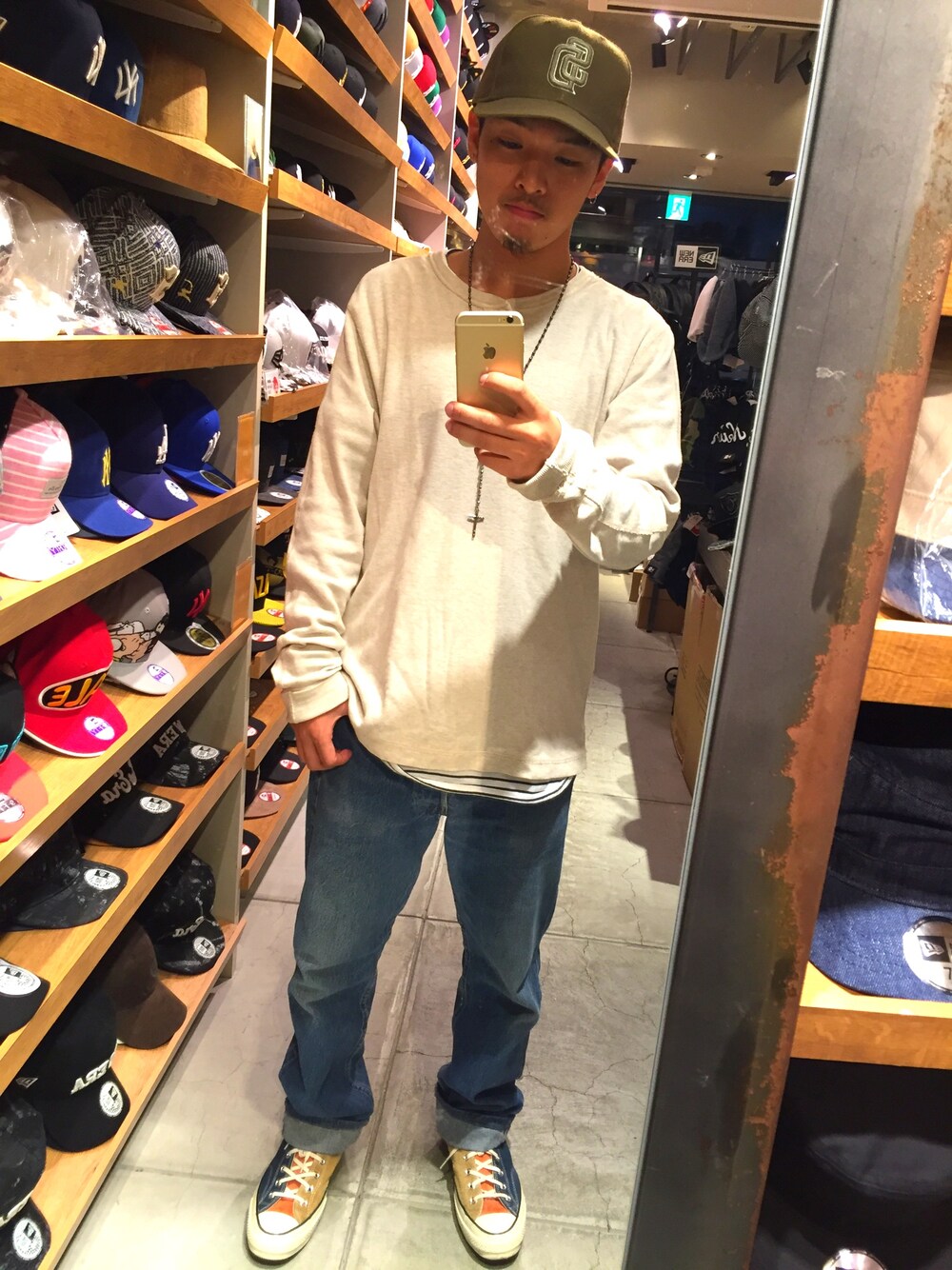 ベージュ系のTシャツ/カットソー、ブルー系のデニムパンツ、その他のスニーカーを着用したメンズの秋コーディネートの1枚目の写真