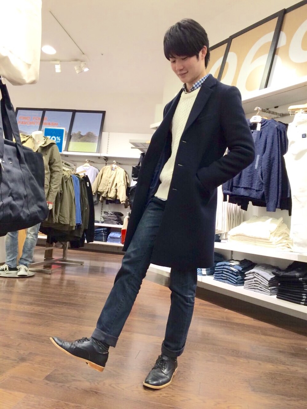 ブルー系のチェスターコート、ホワイト系のニット/セーター、ブルー系のデニムパンツを着用したメンズの冬コーディネートの1枚目の写真