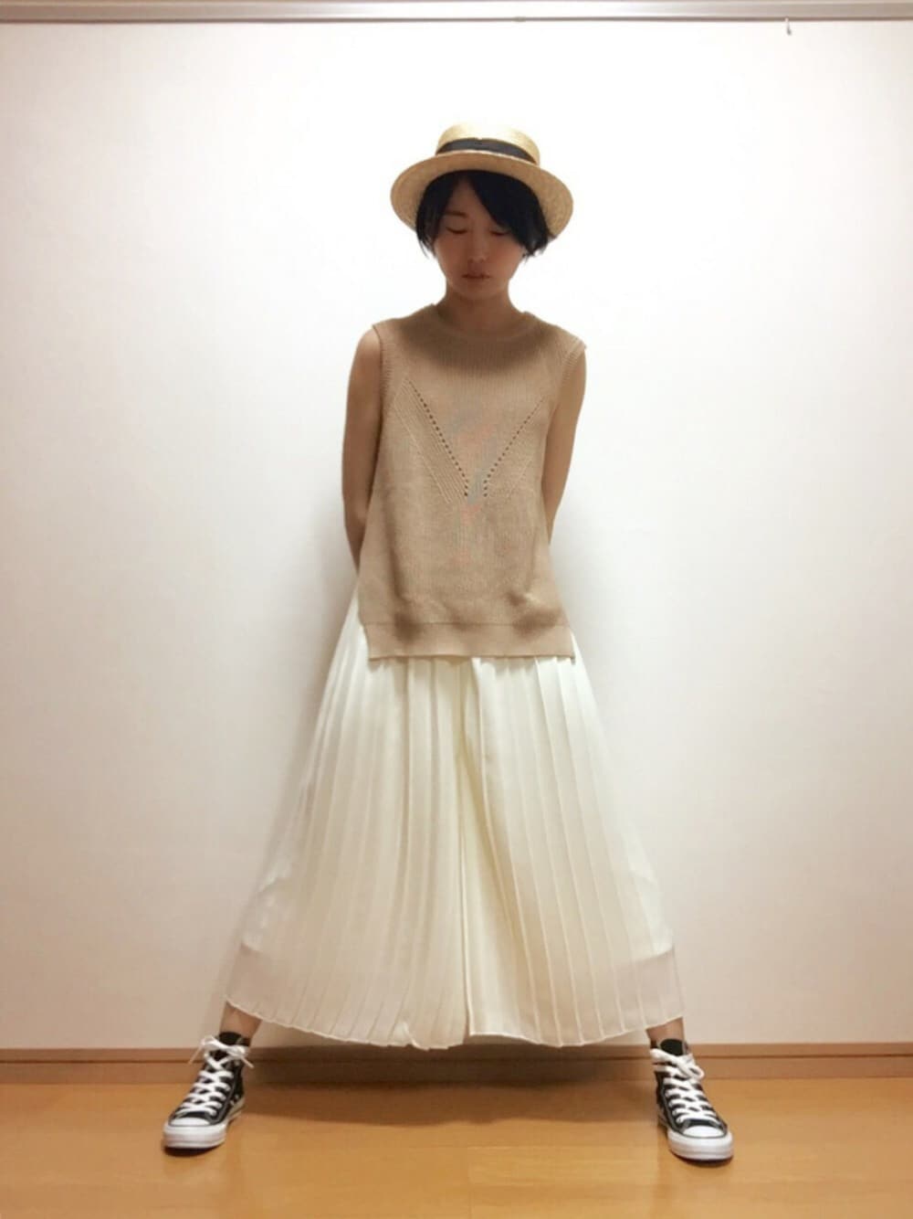 ベージュ系のニット/セーター、ブラック系のスニーカー、ホワイト系のその他パンツを着用したレディースの春コーディネートの1枚目の写真