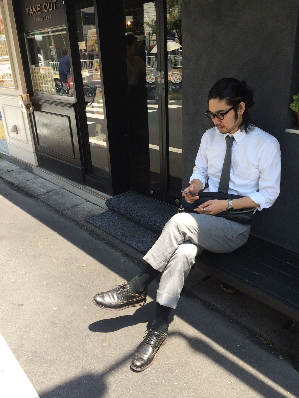 グレー系のネクタイ、ホワイト系のシャツ/ブラウス、ブラック系のクラッチバッグを着用したメンズの夏コーディネートの1枚目の写真