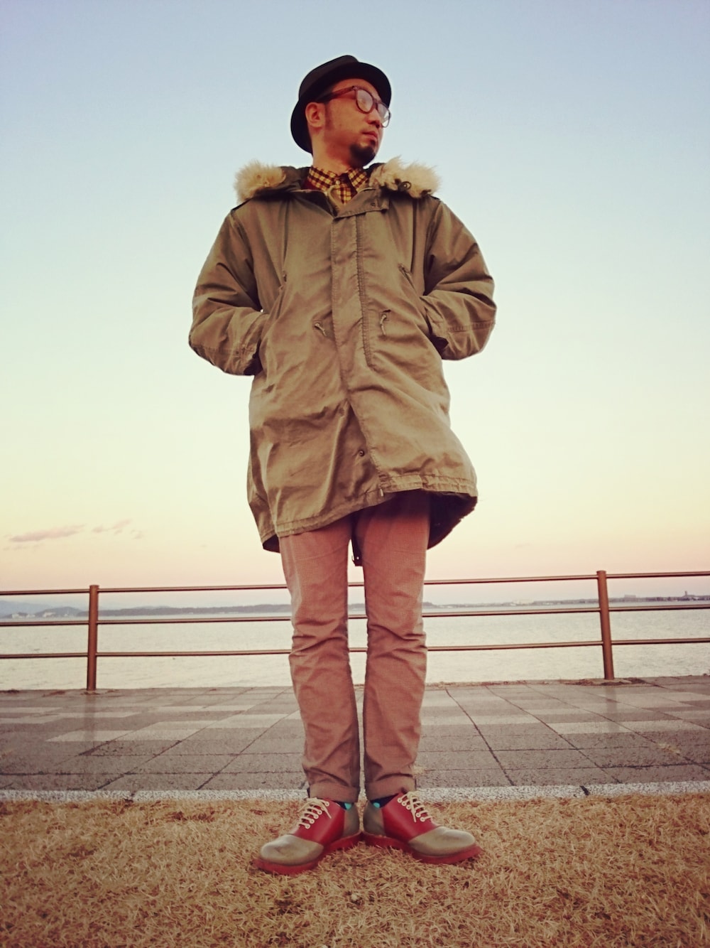 イエロー系のトップス、ブラウン系のニット/セーター、ブラウン系のドレスシューズを着用したメンズの冬コーディネートの1枚目の写真