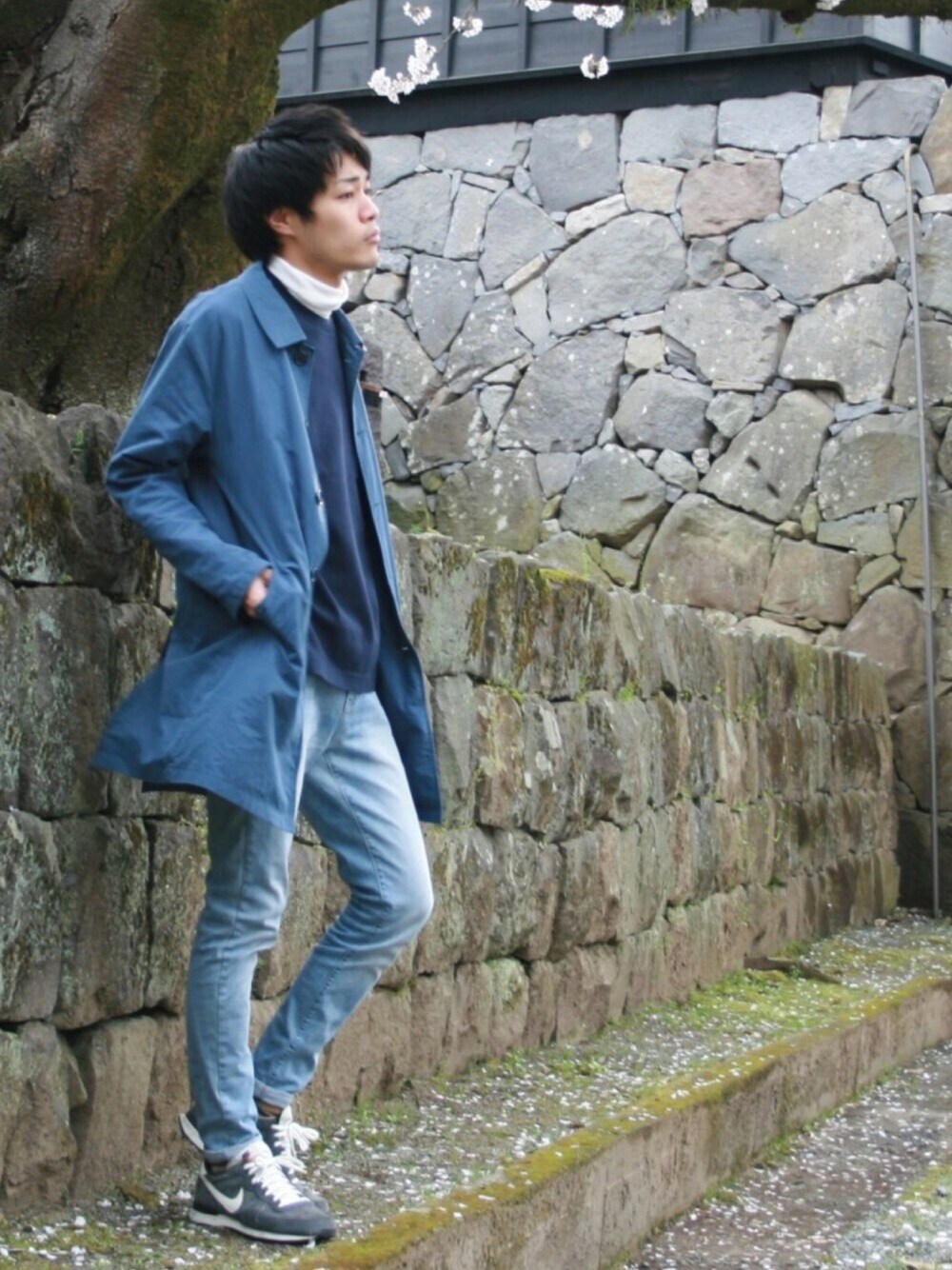 ブルー系のスニーカー、ブルー系のステンカラーコート、ブルー系のデニムパンツを着用したメンズの春コーディネートの1枚目の写真