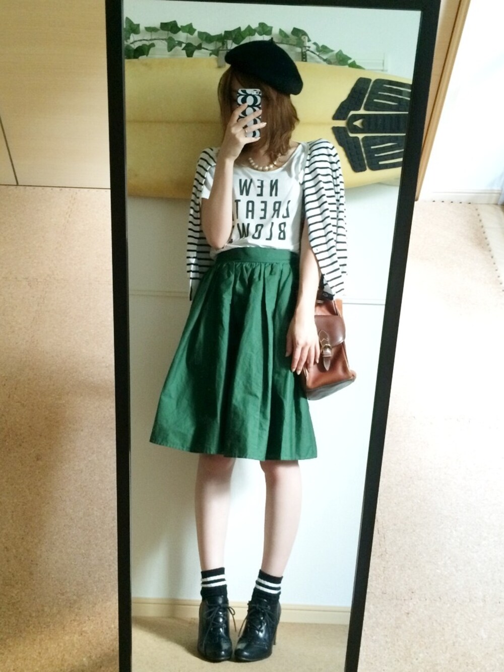 ホワイト系のカーディガン/ボレロ、ホワイト系のTシャツ/カットソー、グリーン系のスカートを着用したレディースの秋コーディネートの1枚目の写真