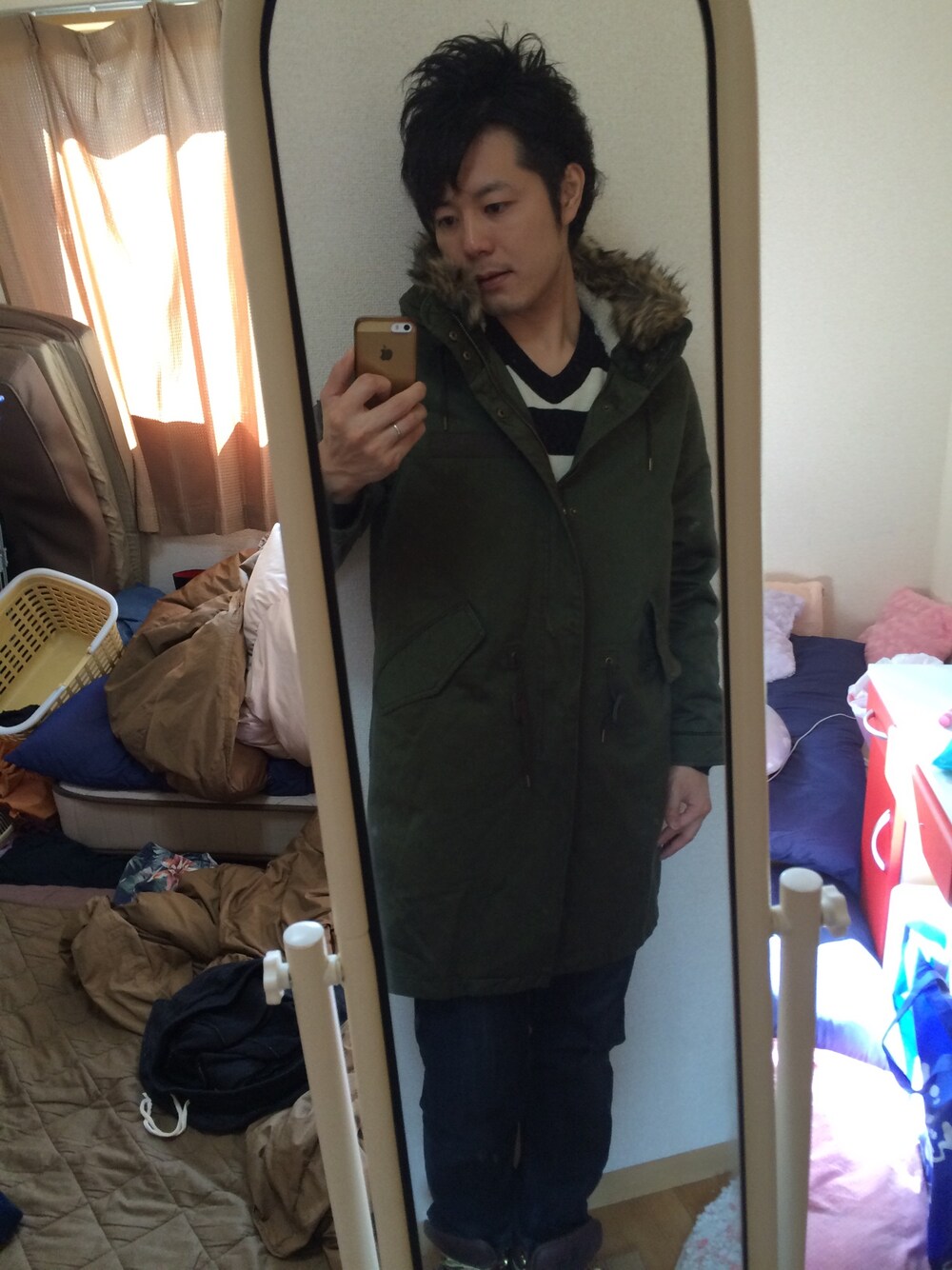 ホワイト系のニット/セーター、グリーン系のモッズコート、ブルー系のデニムパンツを着用したメンズの冬コーディネートの1枚目の写真