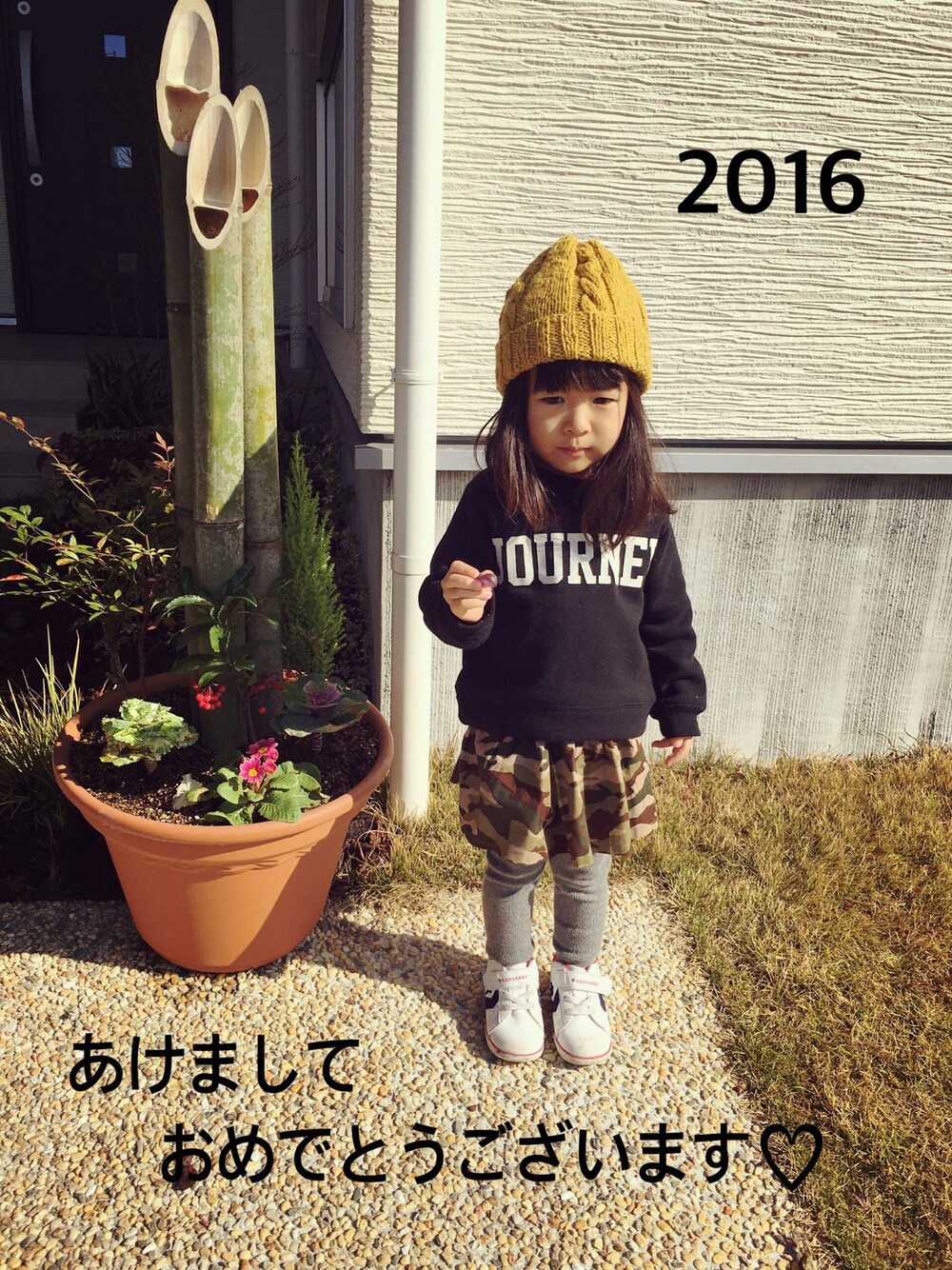 ブラック系のスウェット、ホワイト系のスニーカー、グリーン系のスカートを着用したキッズの冬コーディネートの1枚目の写真