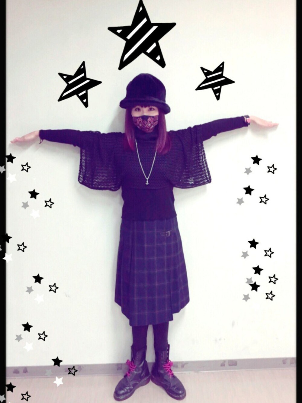 ブラック系のトップス、グリーン系のスカート、ブラック系のブーツを着用したレディースの春コーディネートの1枚目の写真