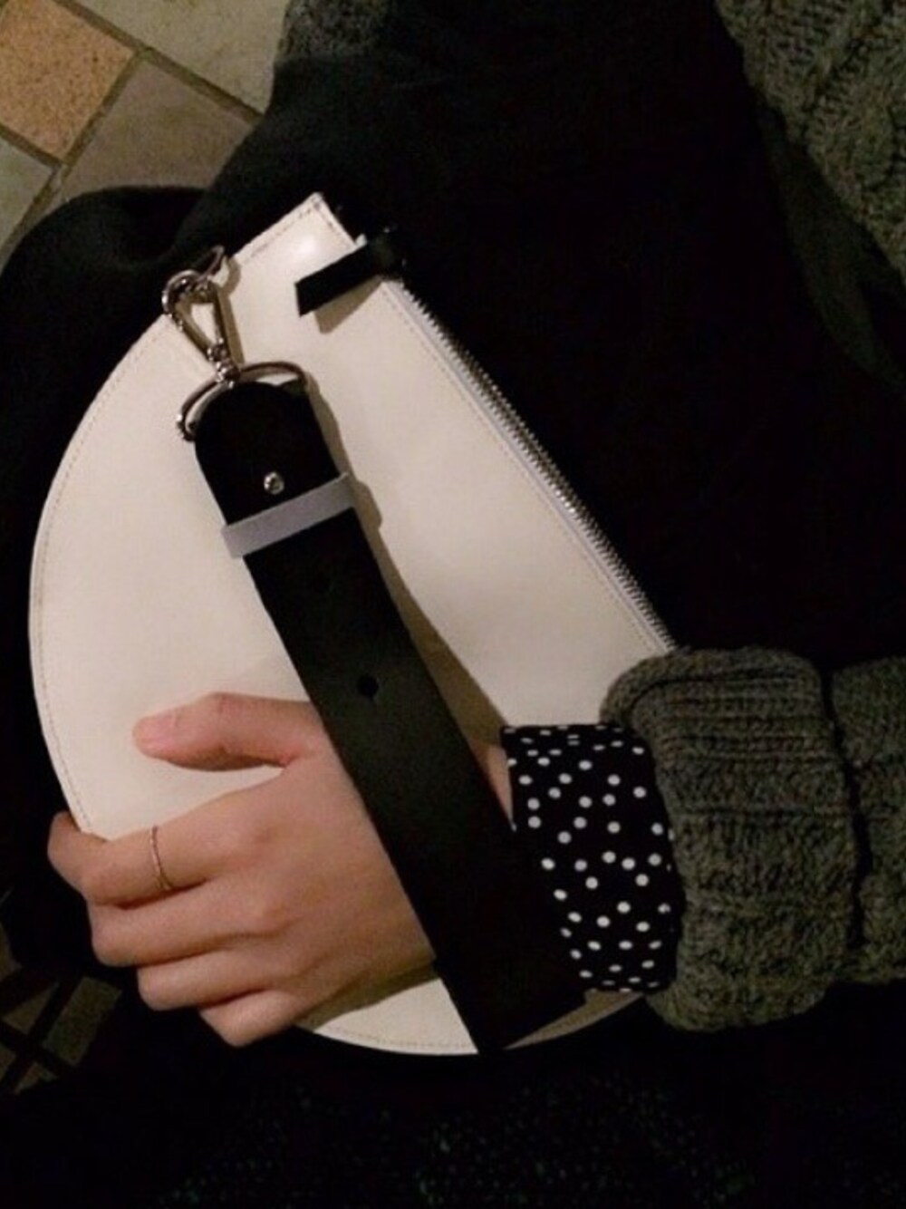 ホワイト系のクラッチバッグを着用したレディースの冬コーディネートの1枚目の写真