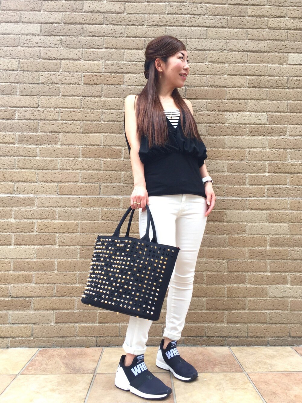 ブラック系のトートバッグ、ブラック系のスニーカー、ホワイト系のその他パンツを着用したレディースの春コーディネートの1枚目の写真