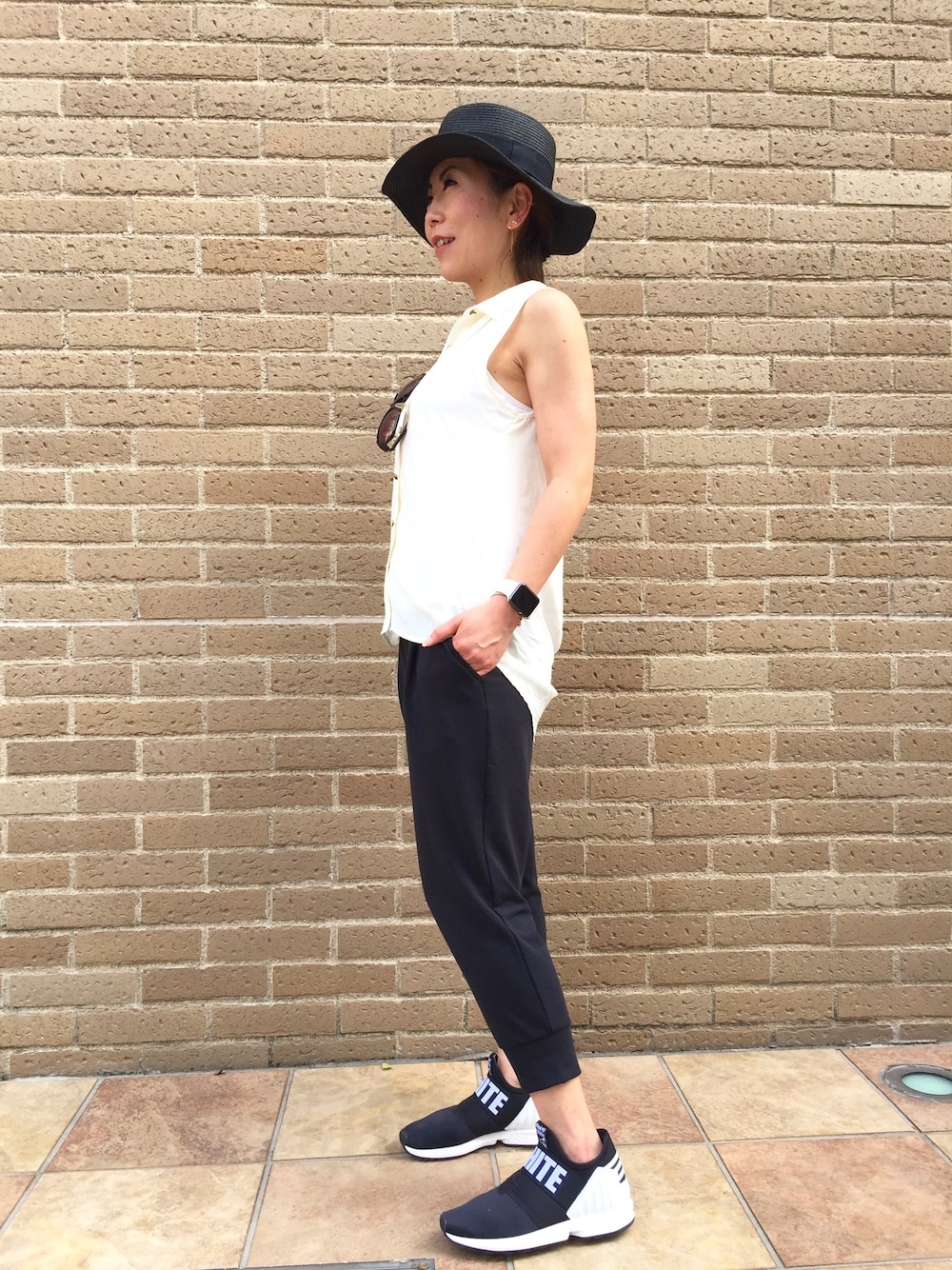 ブラック系のスニーカー、ブラック系のその他パンツ、ホワイト系のシャツ/ブラウスを着用したレディースの夏コーディネートの1枚目の写真