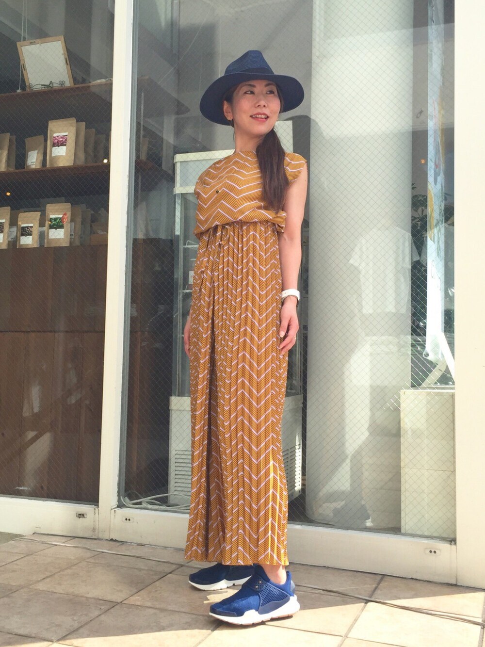 オレンジ系のつなぎ/オールインワン、ブルー系のスニーカー、ゴールド系のブレスレットを着用したレディースの夏コーディネートの1枚目の写真