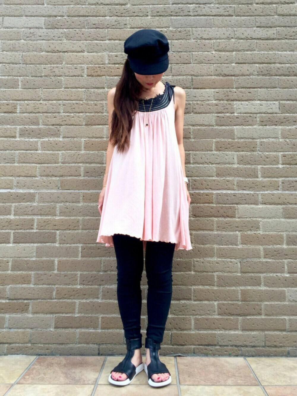 ピンク系のワンピース、ブラック系のサンダル、ブラック系のタンクトップを着用したレディースの夏コーディネートの1枚目の写真