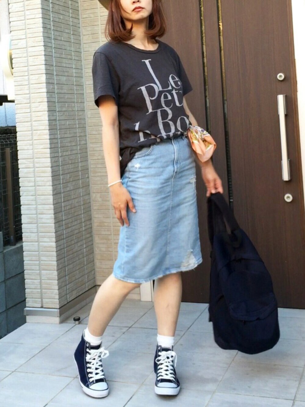 ブラック系のTシャツ/カットソー、ブルー系のスニーカー、ブルー系のデニムスカートを着用したレディースの夏コーディネートの1枚目の写真