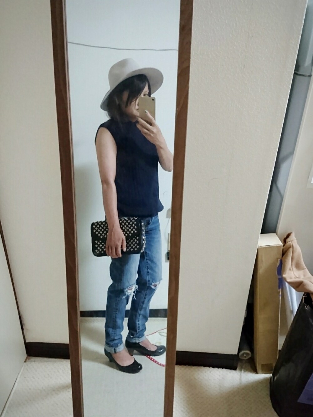 ブラック系のショルダーバッグ、ブルー系のデニムパンツ、ブルー系のベストを着用したレディースの夏コーディネートの1枚目の写真