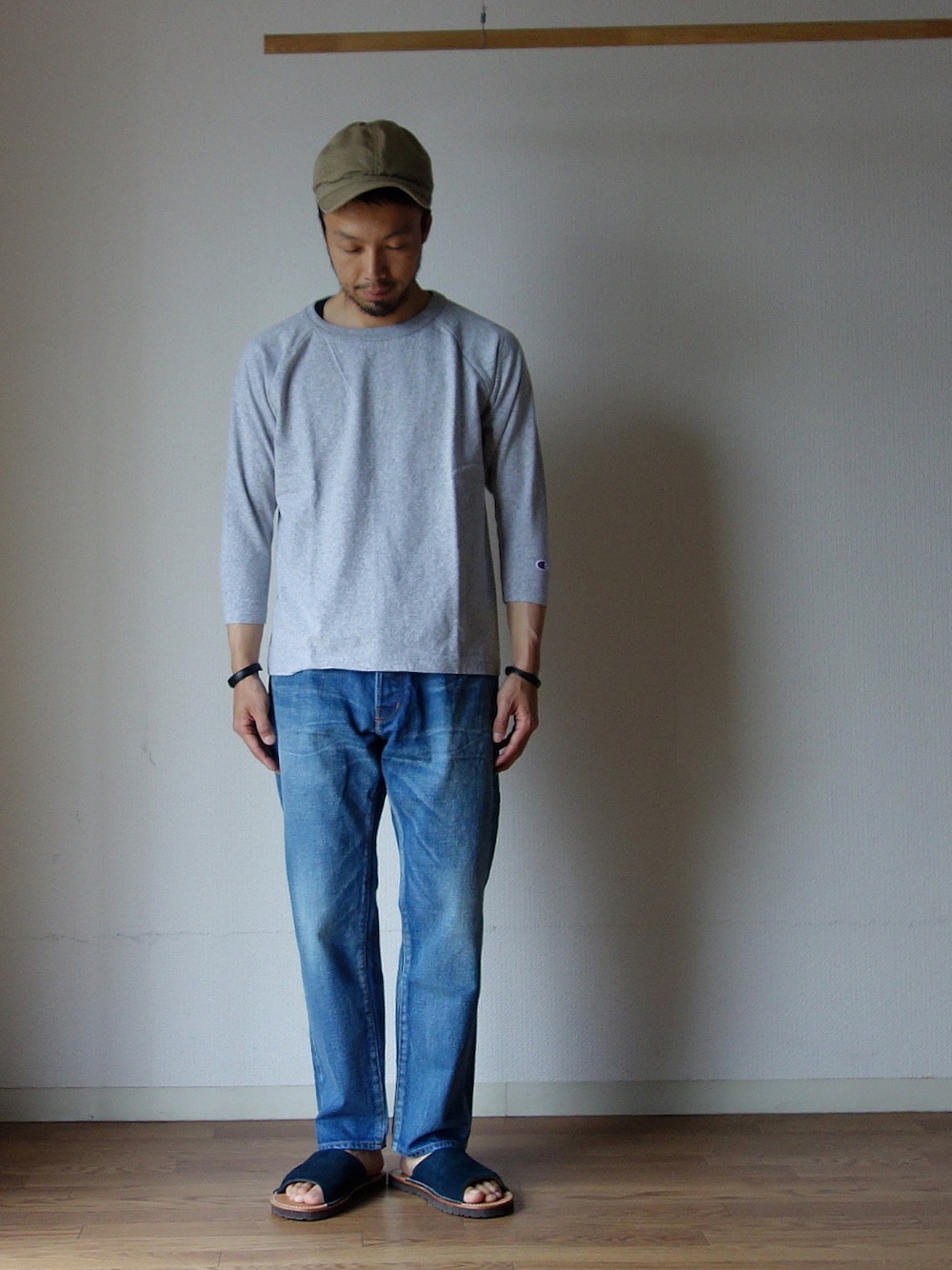 グレー系のTシャツ/カットソー、ブルー系のデニムパンツを着用したメンズの春コーディネートの1枚目の写真
