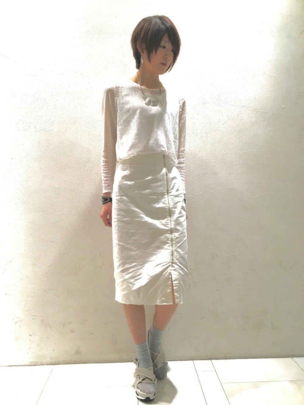 ホワイト系のサンダル、ホワイト系のTシャツ/カットソー、ホワイト系のスカートを着用したレディースの春コーディネートの1枚目の写真