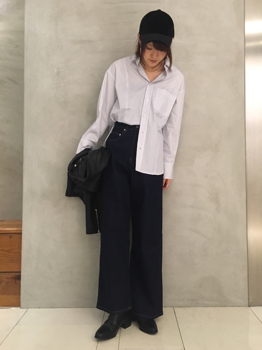 グレー系のシャツ/ブラウス、ブルー系のデニムパンツ、ブラック系のライダースジャケットを着用したレディースの秋コーディネートの1枚目の写真