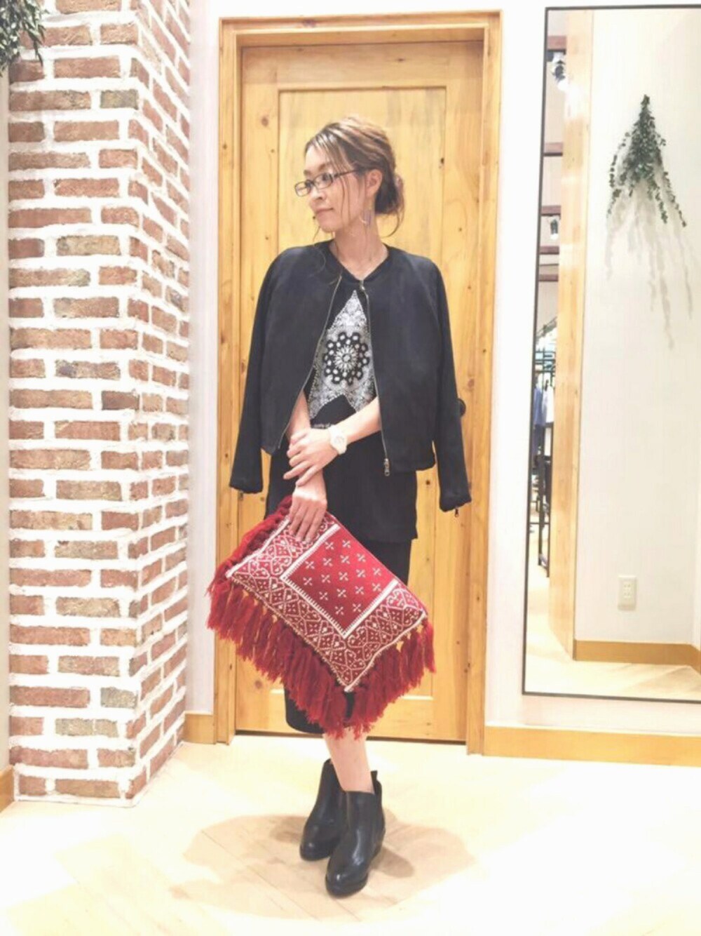 ブラック系のノーカラージャケット、ブラック系のTシャツ/カットソー、ブラック系のスカートを着用したレディースの秋コーディネートの1枚目の写真