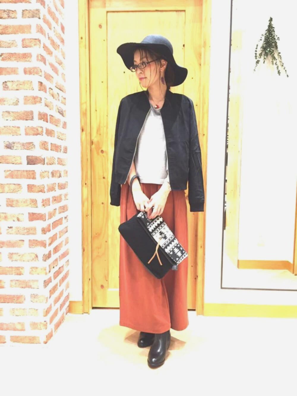 ブラック系のMA-1、グレー系のニット/セーター、レッド系のその他パンツを着用したレディースの秋コーディネートの1枚目の写真