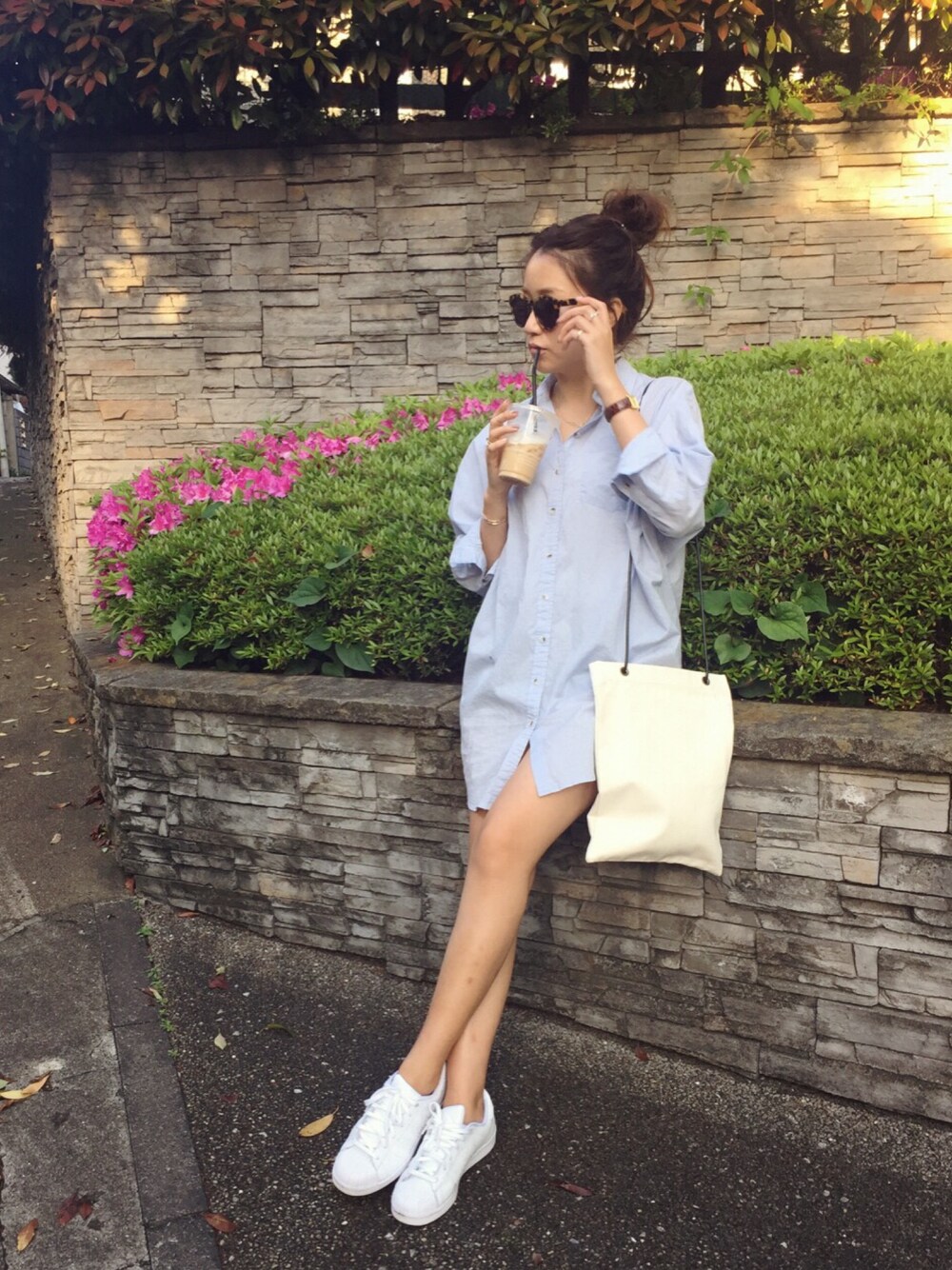 ブルー系のワンピース、ホワイト系のショルダーバッグ、ホワイト系のスニーカーを着用したレディースの春コーディネートの1枚目の写真