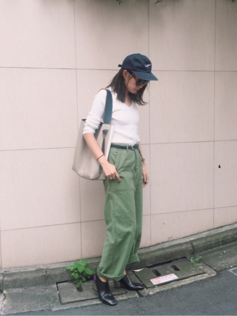 グリーン系のカーゴパンツ、ホワイト系のニット/セーターを着用したレディースの秋コーディネートの1枚目の写真