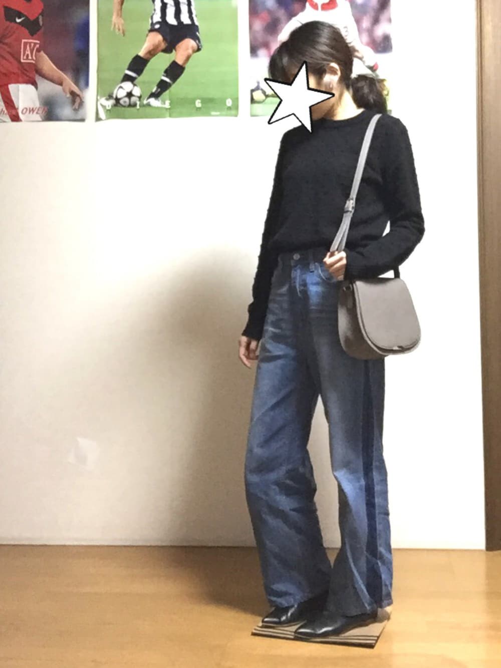 ブラック系のニット/セーター、ブルー系のデニムパンツ、グレー系のショルダーバッグを着用したレディースの秋コーディネートの1枚目の写真