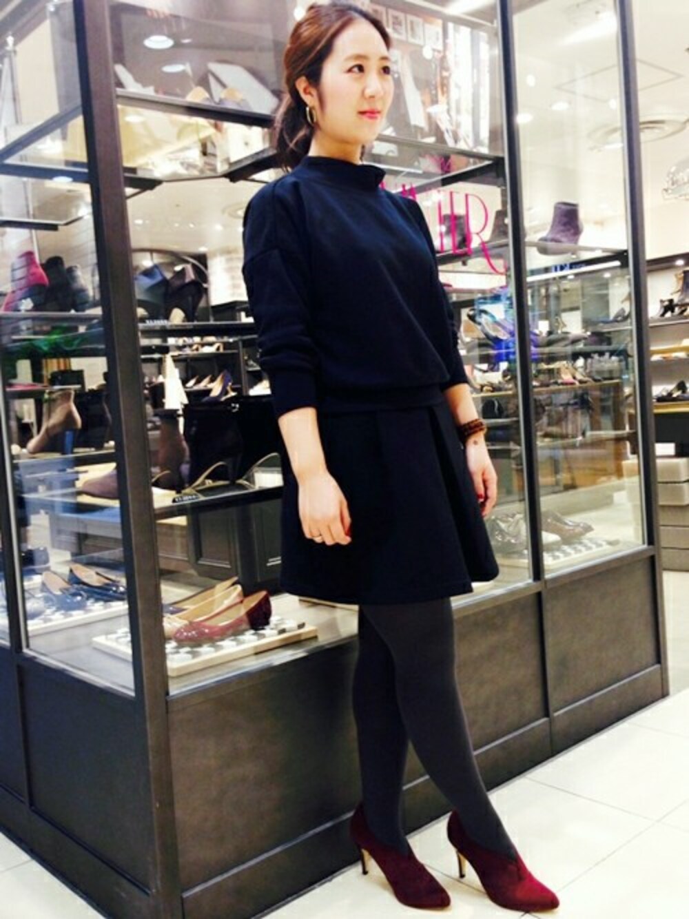 レッド系のブーティを着用したレディースの冬コーディネートの1枚目の写真