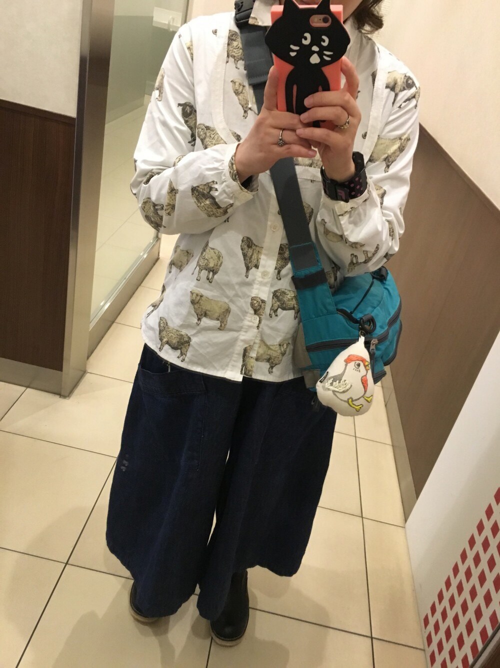 ブルー系のボディバッグ/ウエストポーチ、ブラック系のブーツ、ホワイト系のシャツ/ブラウスを着用したレディースの春コーディネートの1枚目の写真