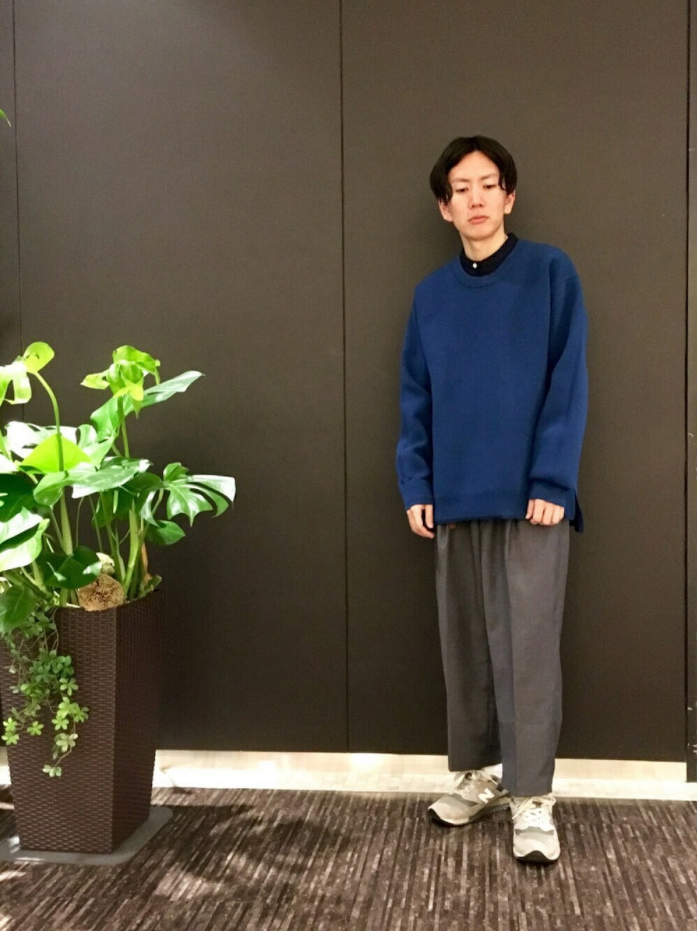 ブルー系のニット/セーター、イエロー系のシャツ/ブラウス、グレー系のその他パンツを着用したメンズの秋コーディネートの1枚目の写真