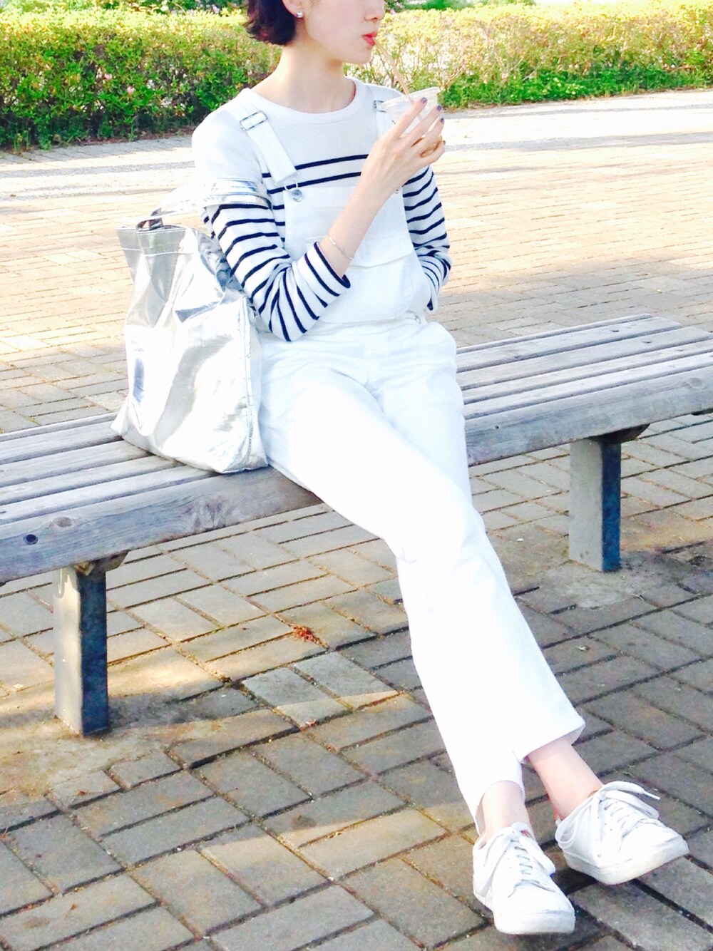 ホワイト系のサロペット/オーバーオール、ホワイト系のニット/セーター、ホワイト系のスニーカーを着用したレディースの春コーディネートの1枚目の写真