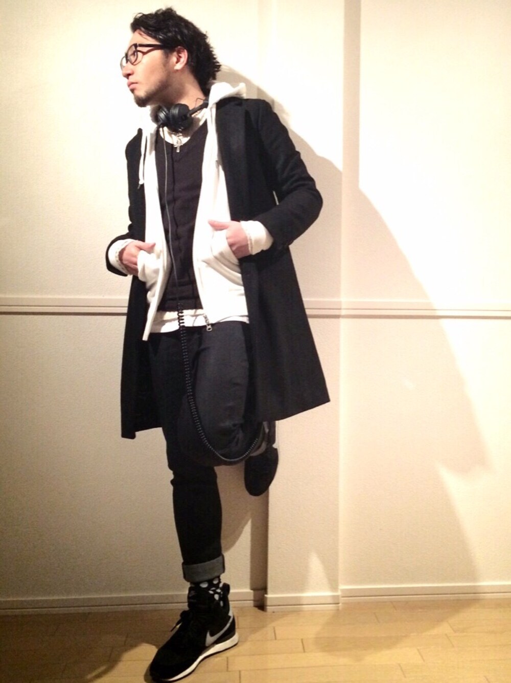 ブラック系のチェスターコート、ホワイト系のパーカー、ブラック系のベストを着用したメンズの冬コーディネートの1枚目の写真