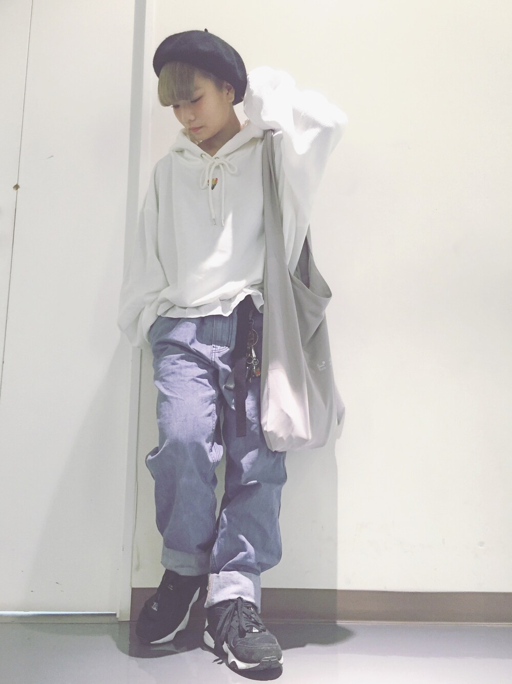 ホワイト系のパーカー、グレー系のトートバッグ、ブルー系のパンツを着用したレディースの春コーディネートの1枚目の写真