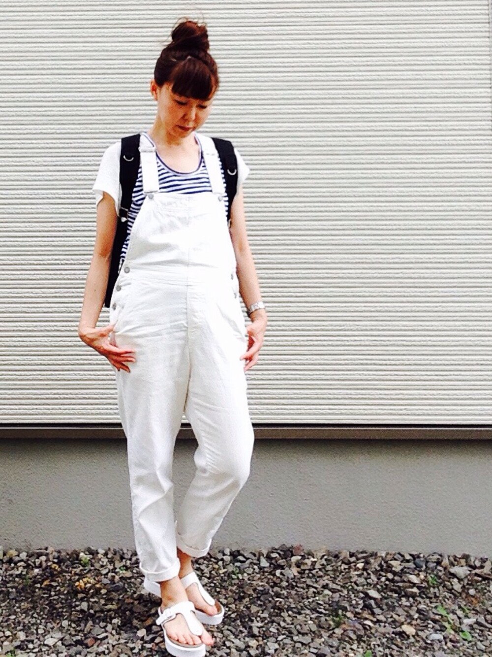 ブラック系のバックパック/リュック、ブルー系のTシャツ/カットソー、ホワイト系のサロペット/オーバーオールを着用したレディースの夏コーディネートの1枚目の写真