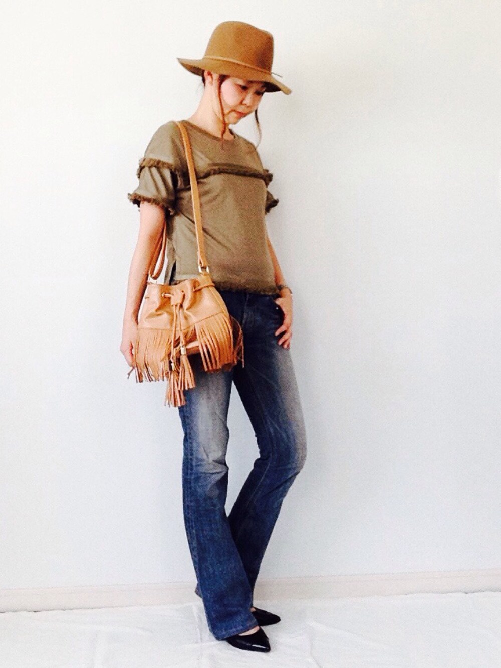 グリーン系のTシャツ/カットソー、イエロー系のショルダーバッグ、ベージュ系のハットを着用したレディースの夏コーディネートの1枚目の写真