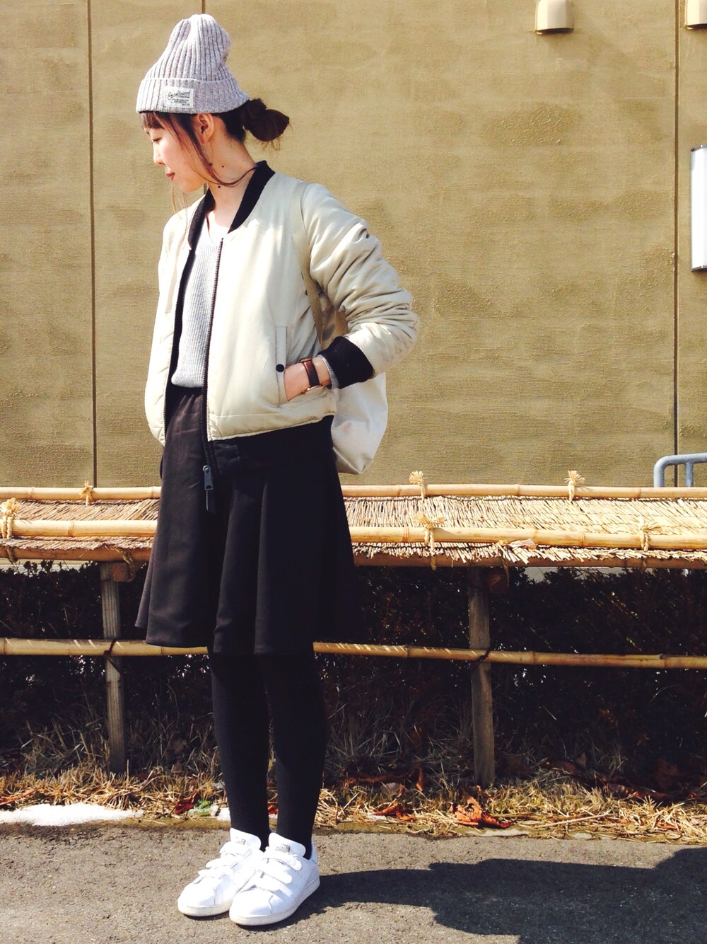 ブラック系のMA-1、グレー系のニット/セーター、ホワイト系のバックパック/リュックを着用したレディースの春コーディネートの1枚目の写真