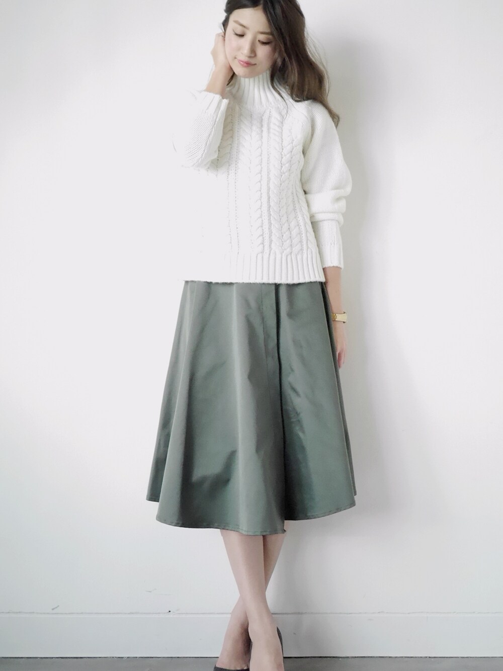 ホワイト系のニット/セーター、グリーン系のスカートを着用したレディースの秋コーディネートの1枚目の写真