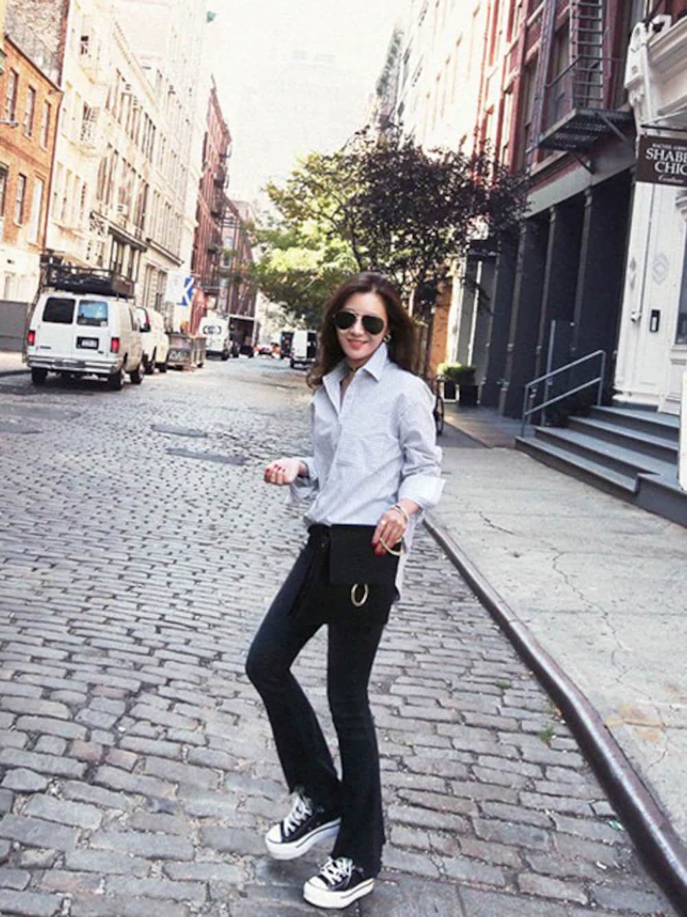 ホワイト系のシャツ/ブラウス、ブラック系のデニムパンツ、ブラック系のクラッチバッグを着用したレディースの秋コーディネートの1枚目の写真