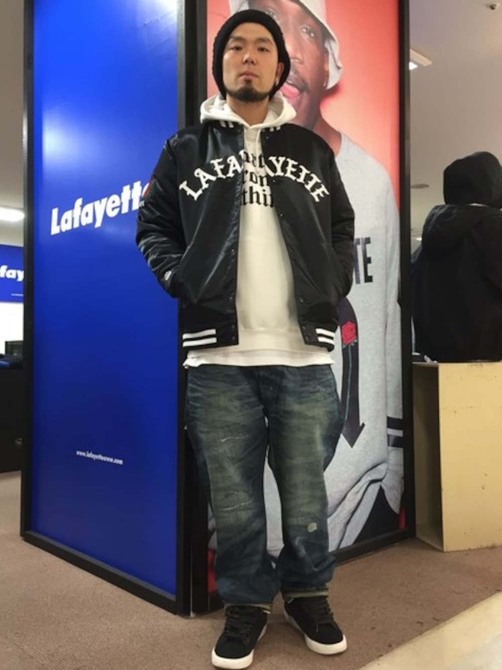 ブラック系のスタジャン、ホワイト系のパーカー、ブルー系のデニムパンツを着用したメンズの冬コーディネートの1枚目の写真