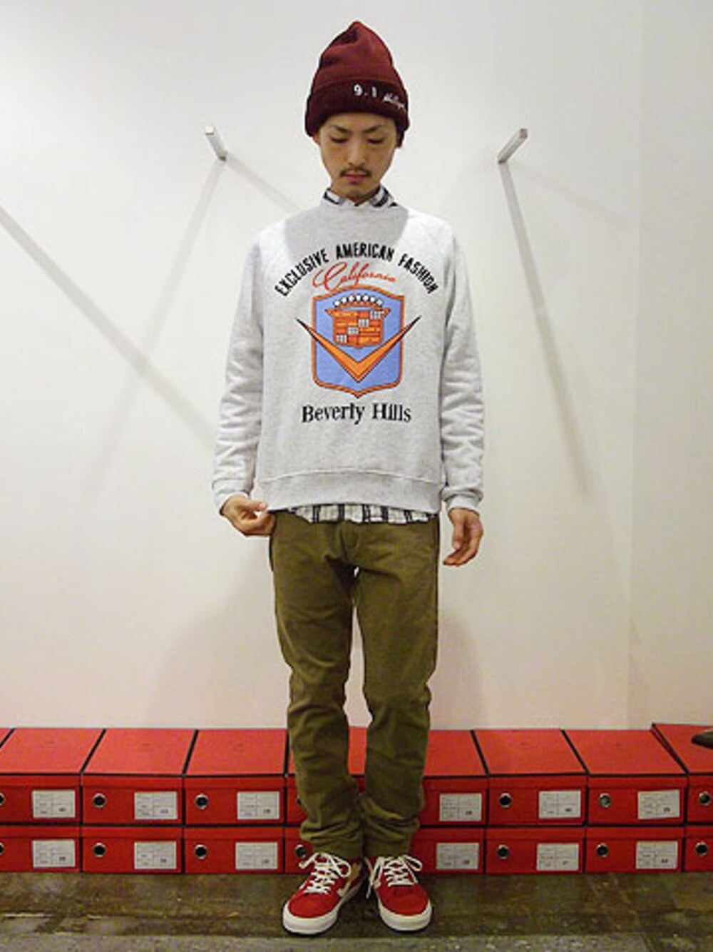 「スウェット、スニーカー、コーデュロイ、VANS、シャツ、チェックシャツ、ニット帽、ニットキャップ、JOYRICH、HOLLYWOOD MADE」｜「HOLLYWOOD MADEのHOLLYWOOD MADE/PHILLIP PIMP BEANIE（ニットキャップ/ビーニー、レッド系）」を使った、Reggieさん（メンズ・172cm）の秋コーディネートの1枚目の写真