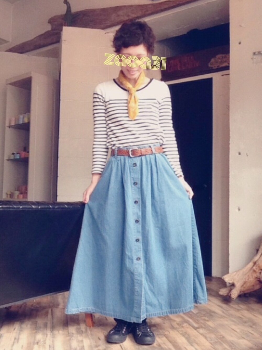 ブラック系のスニーカー、ブルー系のデニムスカート、ホワイト系のTシャツ/カットソーを着用したレディースの春コーディネートの1枚目の写真